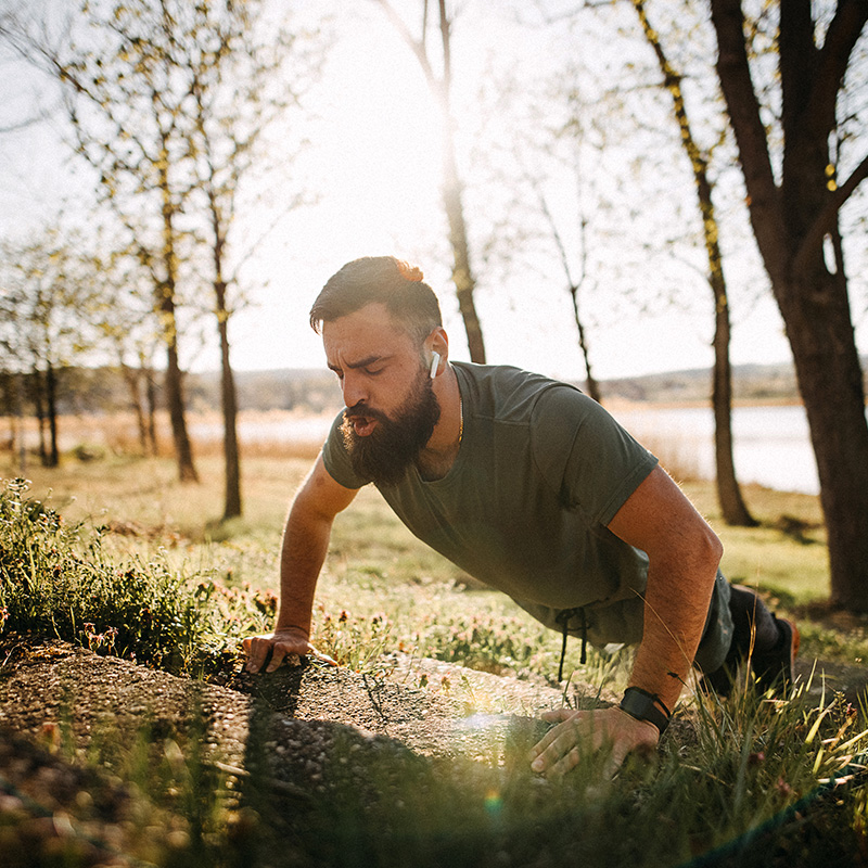 man doing exercises on the ground outdoors for abdominal muscles
