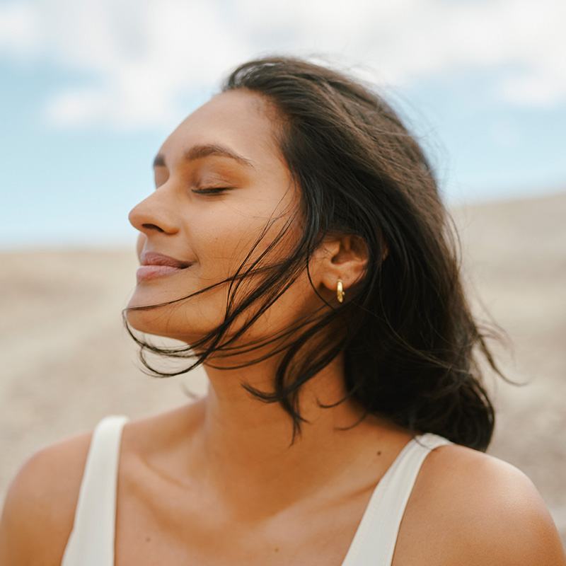 Woman With Glowing Skin Enjoying a Peaceful Breeze